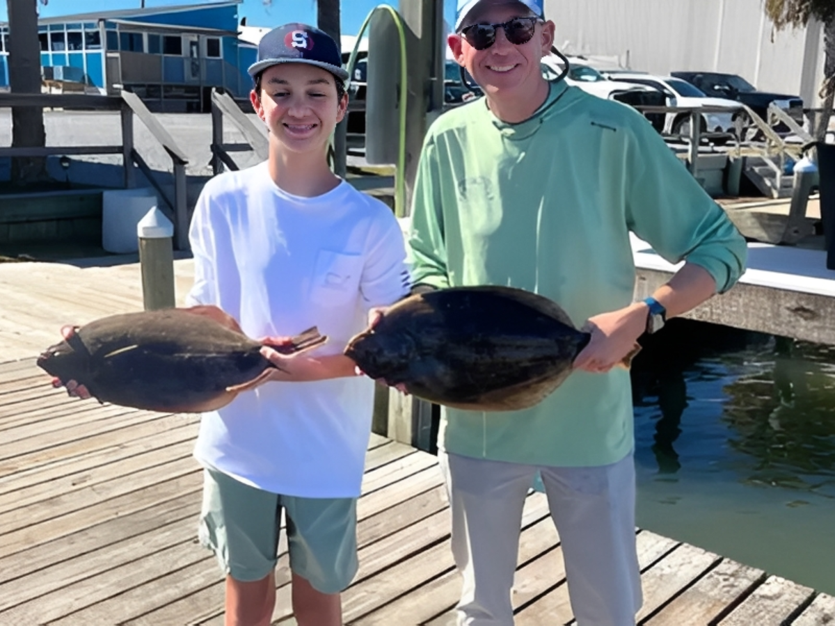Smiling pair displaying their catch.