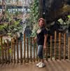 Person standing by a lush indoor garden