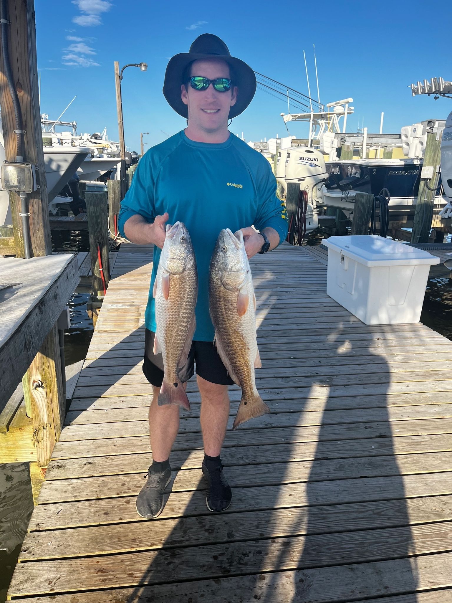 Fisherman with catch on wooden pier