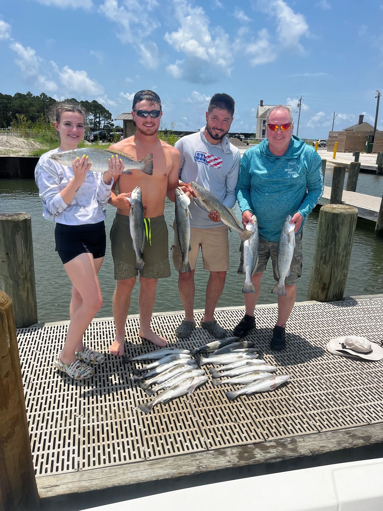 Group holding fish on a dock