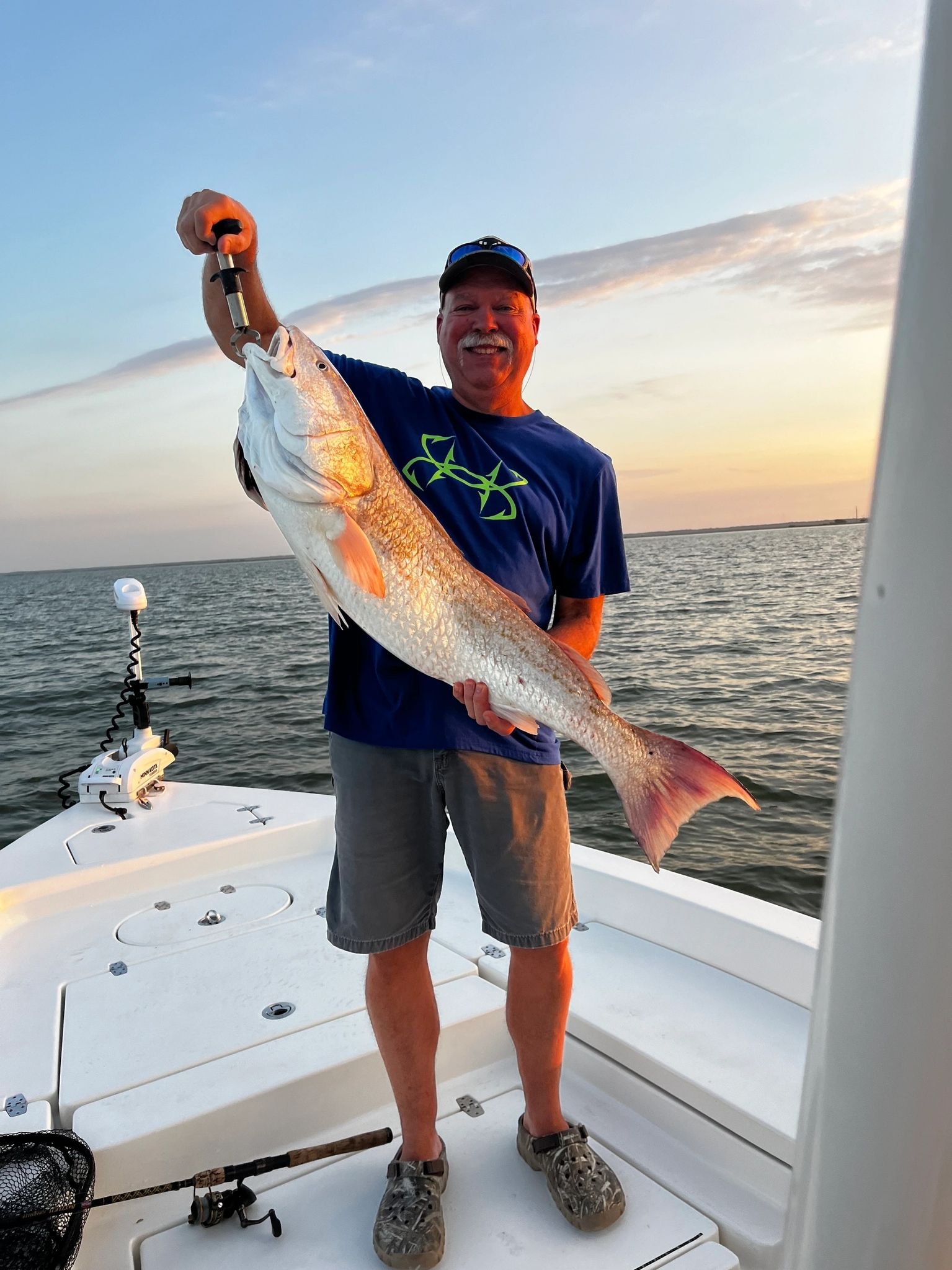 Man holding large fish on boat